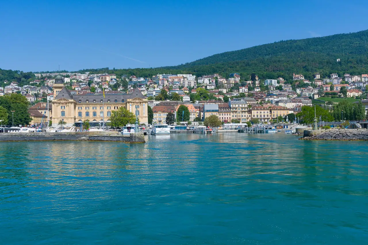 Le port de Neuchâtel, ses bateaux et la ville au pied de la forêt